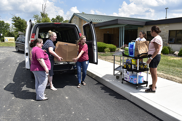 Buchanan volunteers carry in donations for Scott Academy